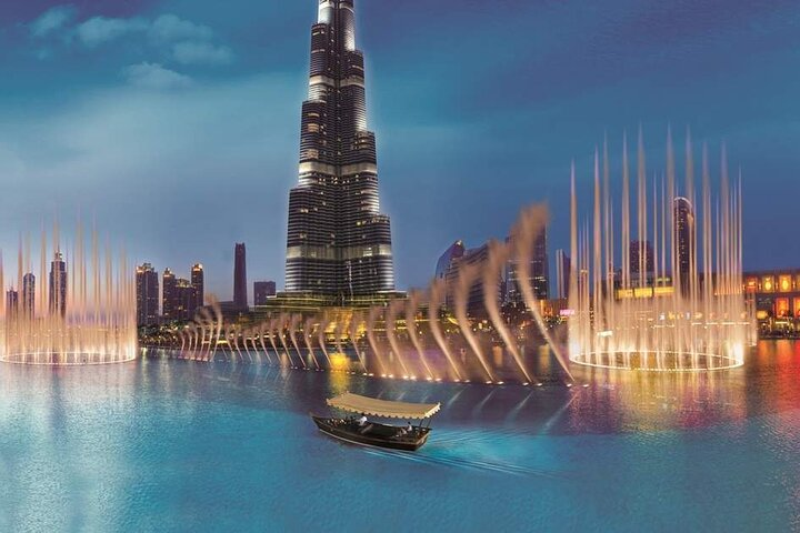 Experience the beauty of the Dubai Fountain Show with a serene boat ride on Burj Lake enjoying spectacular views as water dances in sync with lights against the skyline.